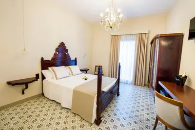 a bedroom with a large bed and a chandelier at Bolet Casa Modernista in Castellví de la Marca
