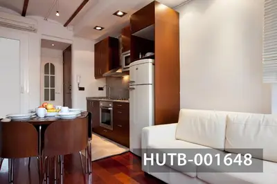 a kitchen with a table and a white refrigerator at Ghat Apartment Poble Sec Barcelona in Barcelona