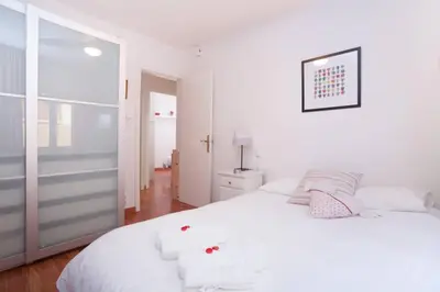 a bedroom with a white bed with towels on it at Apartamento Parc Güell in Barcelona
