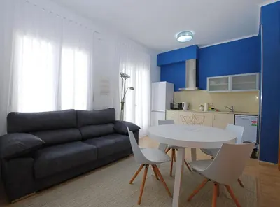 a living room with a couch and a table and chairs at La Platgeta · La Platgeta · Ideal family apartment, with private terrace in Vilassar de Mar
