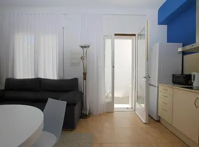 a living room with a couch and a door to a patio at La Platgeta · La Platgeta · Ideal family apartment, with private terrace in Vilassar de Mar