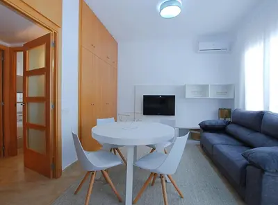 a living room with a table and chairs and a couch at La Platgeta · La Platgeta · Ideal family apartment, with private terrace in Vilassar de Mar