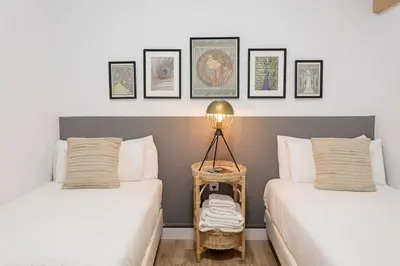 a bedroom with two beds and a lamp on a table at Stylish 3 Bedroom Apartment in Barcelona