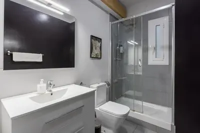 a bathroom with a toilet and a sink and a shower at Stylish 3 Bedroom Apartment in Barcelona