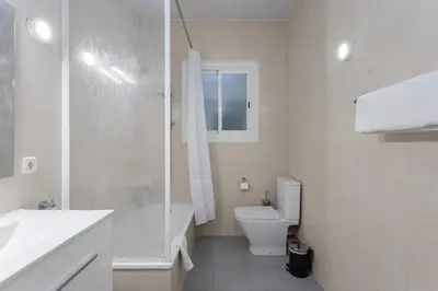 a white bathroom with a toilet and a sink at Stylish 3 Bedroom Apartment in Barcelona