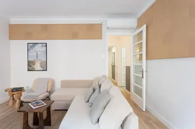 a living room with a white couch and a table at Stylish 3 Bedroom Apartment in Barcelona