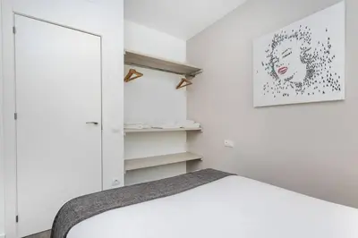 a white bedroom with a bed and a mirror at 3 Bdr&terrace Close To Subway in Hospitalet de Llobregat