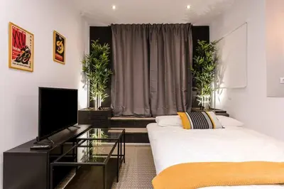 a living room with two beds and a television at 3 Bdr&terrace Close To Subway in Hospitalet de Llobregat