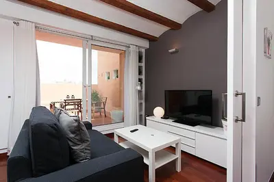 a living room with a couch and a tv at MUNTANYA - Apartments & one with Terrace next to Sagrada Familia in Barcelona