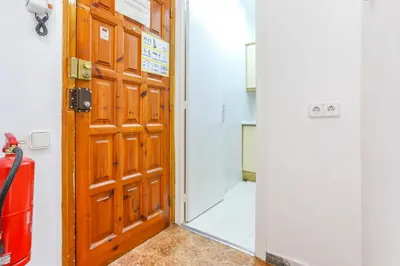 a wooden door in a room with a mirror at Apart Cozy On The Front Line, Liliane in Sitges