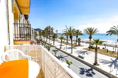 a balcony with a view of the beach and palm trees at Apart Cozy On The Front Line, Liliane in Sitges