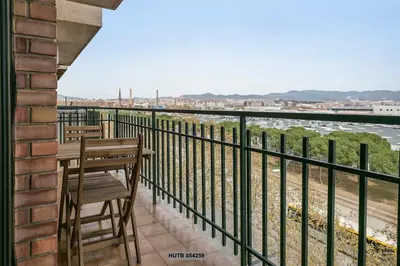 a balcony with a table and chairs looking out over the water at Alcam Sant Adria in Sant Adria de Besos