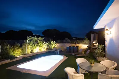 a backyard with a hot tub and a table and chairs at Homestay Villa Estrella - Costa Brava in Calella