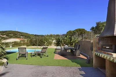 a patio with chairs and a table next to a pool at Homestay Villa Estrella - Costa Brava in Calella