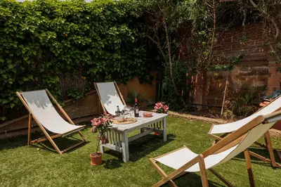 two chairs and a table in a yard with a table and two chairs at CIM Apartments in Olivella
