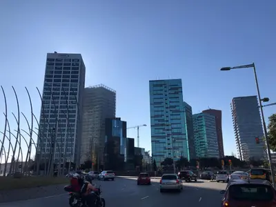 a city with cars and motorcycles on a street with tall buildings at Habitación Amaya 1 in Las Corts