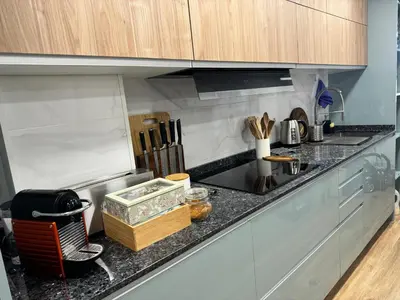 a kitchen with a counter top with wooden cabinets at Habitación Amaya 1 in Las Corts