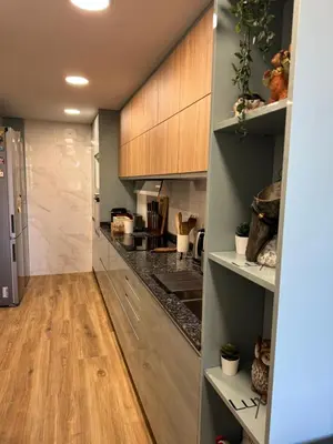a kitchen with wooden cabinets and a hardwood floor at Habitación Amaya 1 in Las Corts