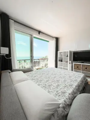 a bedroom with a large bed and a large window at Loft Ponent, Sant Pol de Mar in San Pol de Mar
