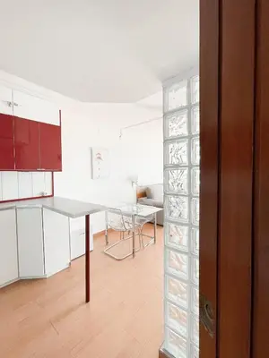 a kitchen with white cabinets and a table in a room at Loft Ponent, Sant Pol de Mar in San Pol de Mar
