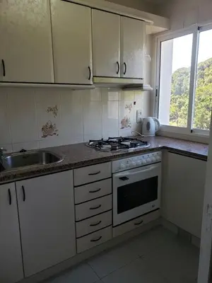 a kitchen with white cabinets and a sink and a stove at Apart.3 habit.mar-mont. AC-Terraza-ascensor-parking in Calella