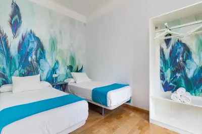 two beds in a room with a mural on the wall at Art House Station Rocafort ´Sant Antoni´ in Barcelona