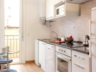 a kitchen with white appliances and a glass table at Sagrada Familia in Barcelona