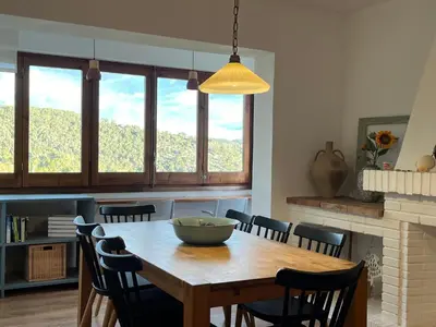 a dining room with a wooden table and chairs at TERRAVU in Sant Pere de Ribes