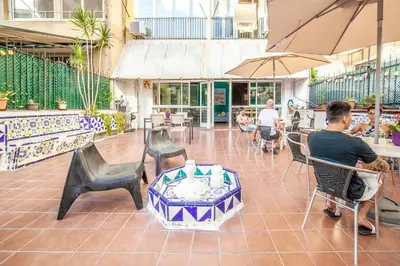 a man sitting in a chair at a restaurant at Fabrizzios Terrace Hostel in Barcelona