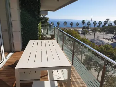 a white bench on a balcony with a view of the beach at Apartamento Bea Beach in Badalona