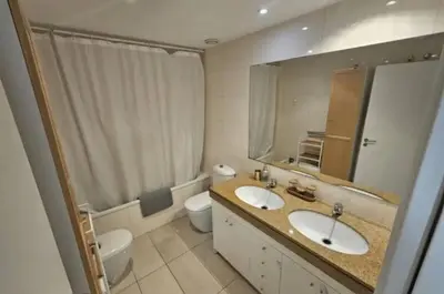 a bathroom with two sinks and a toilet and a mirror at Apartamento Bea Beach in Badalona