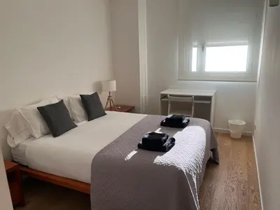 a bedroom with a bed with two bags on it at Apartamento Bea Beach in Badalona
