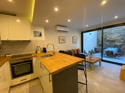 a kitchen with a counter top and a living room at Beautiful apartment 5 minutes walk to the beach in Caldes d'Estrac
