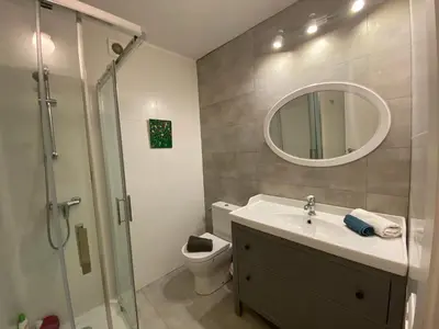 a bathroom with a sink and a toilet and a mirror at Beautiful apartment 5 minutes walk to the beach in Caldes d'Estrac