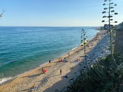 a group of people on a beach near the ocean at Beautiful apartment 5 minutes walk to the beach in Caldes d'Estrac