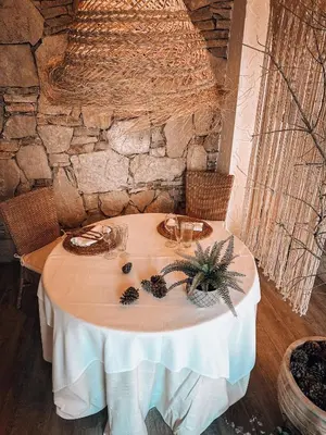 a table with a white table cloth and some wine glasses at Suite con Burbuja in Canyelles