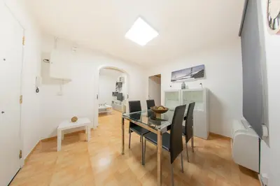 a dining room with a glass table and black chairs at Ahllenrock Cornellà - Parking Gratis- Cerca BCN in Cornellà de Llobregat