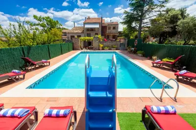 a swimming pool with a slide in a yard at 8 to 10 Sleeps Private Pool Villa & BBQ Near Barcelona in Rocafort