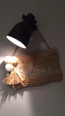 a light on a wall with a hat and a purse at Casa Feliz in Sant Cebrià de Vallalta
