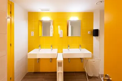 a bathroom with two sinks and two mirrors at Hostelle - Women only hostel Barcelona in Barcelona