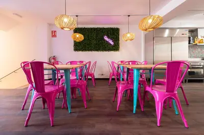 a room with pink tables and pink chairs at Hostelle - Women only hostel Barcelona in Barcelona