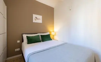 a small bedroom with a bed with green pillows at Stay U-nique Apartments Radas in Barcelona