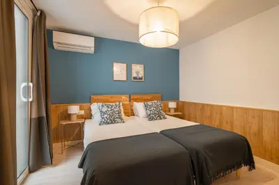 a bedroom with a bed with a blue wall at Stay U-nique Apartments Aribau in Barcelona