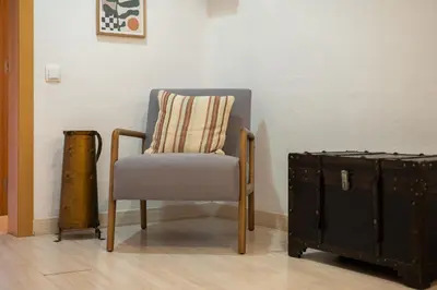 a chair with a pillow next to a chest at Stay U-nique Apartments Aribau in Barcelona