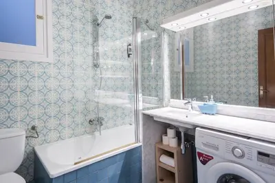 a bathroom with a sink and a washing machine at Spacious 3 bed Apt in the heart of Sant Antoni, Barcelona in Barcelona