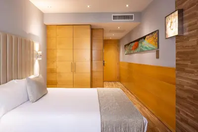 a bedroom with a white bed and wooden cabinets at Hotel Sansi Barcelona in Barcelona