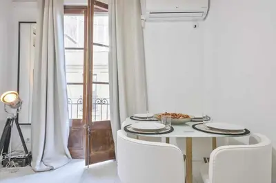 a white dining room with a table and chairs at Apartamento Alejandro en BCN in Barcelona