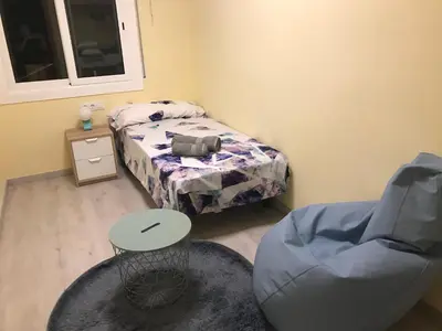 a small room with a bed and a chair at Cerdanyola centro in Cerdanyola del Valles