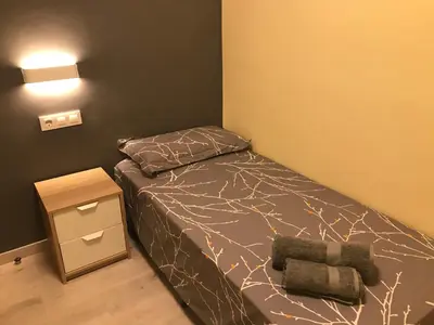 a small bedroom with a bed and a night stand at Cerdanyola centro in Cerdanyola del Valles