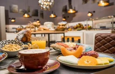 a table topped with plates of food and drinks at Leonardo Royal Hotel Barcelona Fira in Barcelona